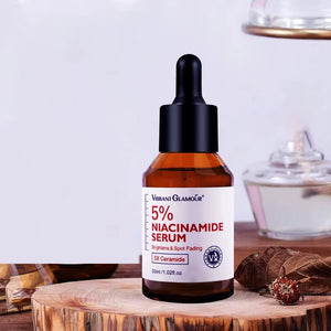 A bottle of Vibrant Glamour 5% Niacinamide Serum with a dropper, placed on a wooden surface with a blurred background.